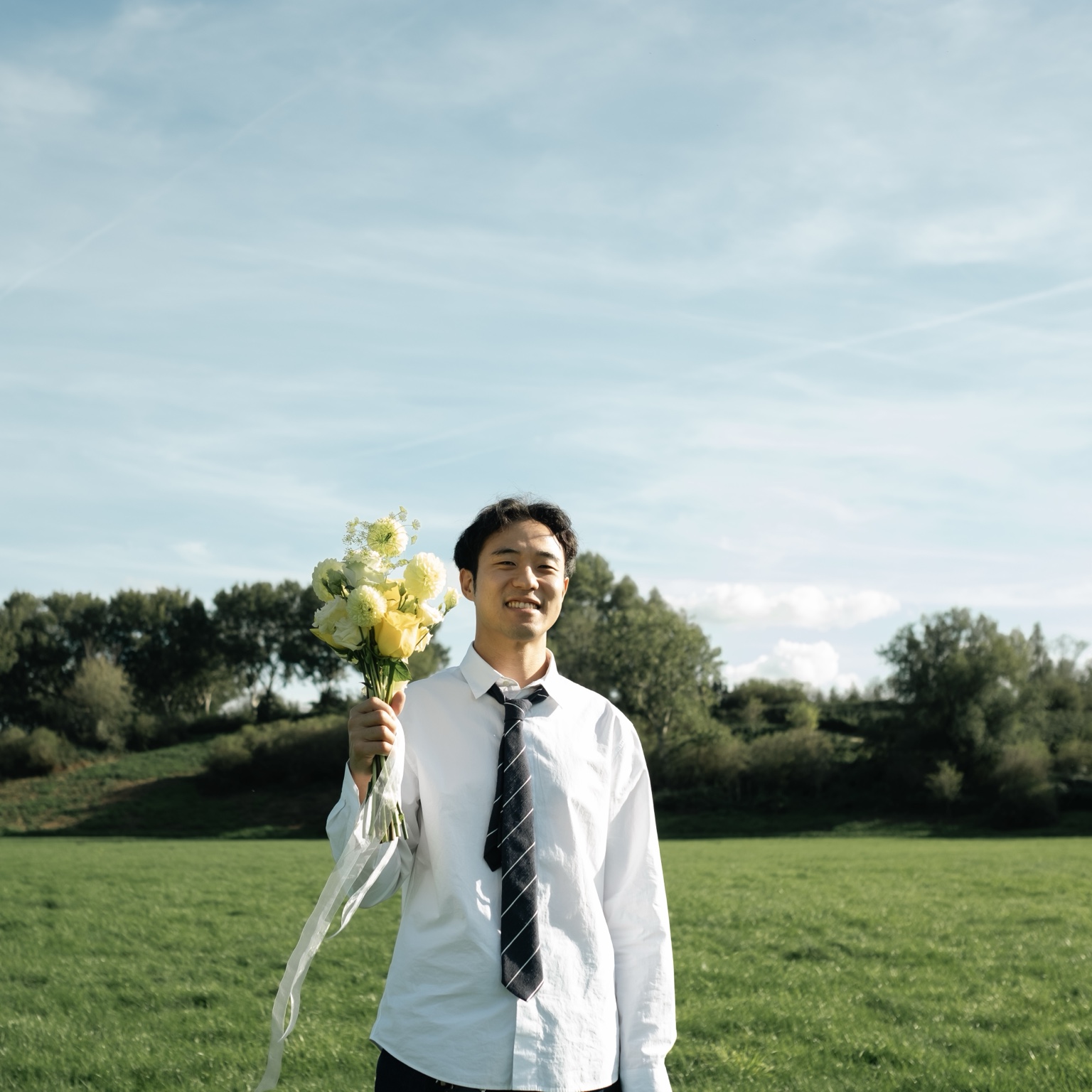 Daniel holding the bouquet in the meadow